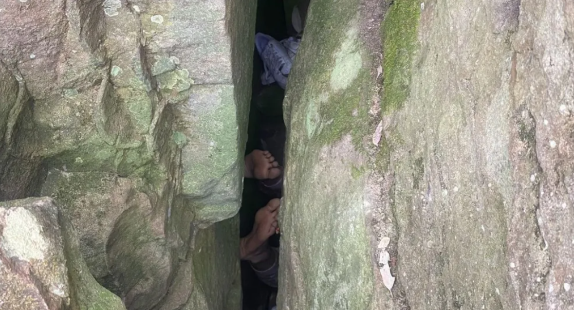 Woman reaching for phone gets stuck upside down in boulders