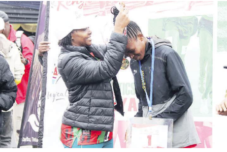 KTB CEO June Chepkemei awards Ruth Gitonga after winning the women’s 13.5km during the Logonot Trail Challenge in Naivasha /