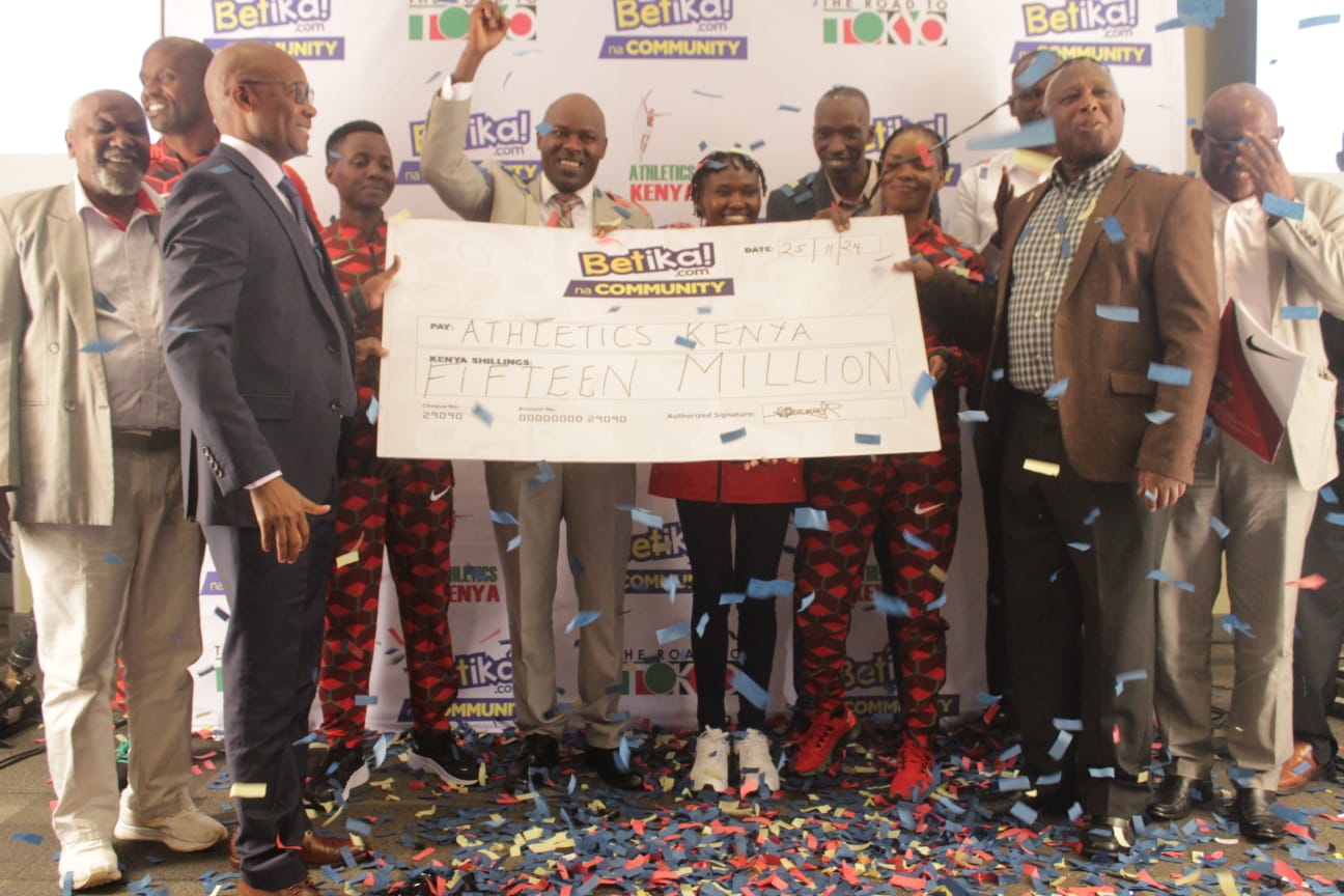 Betika CEO Mutua Mutava (L) Athletics Kenya President Jack Tuwei (R) along with athletes holding a dummy cheque/ TEDDY MULEI