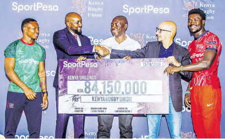 KRU Chairman Alexander Mutai receives a dummy cheque from Sportpesa CEO Ronald Karauri
