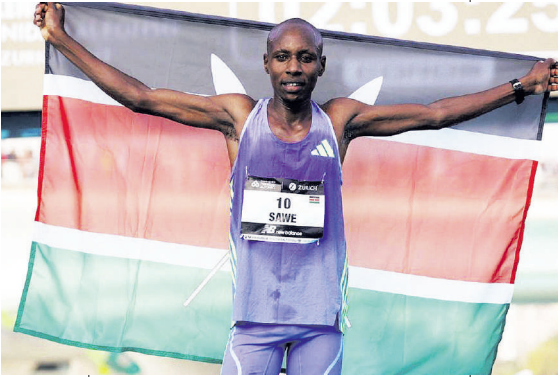 Sebastian Sawe celebrates with Kenyan flag after winning  in Valencia Marathon