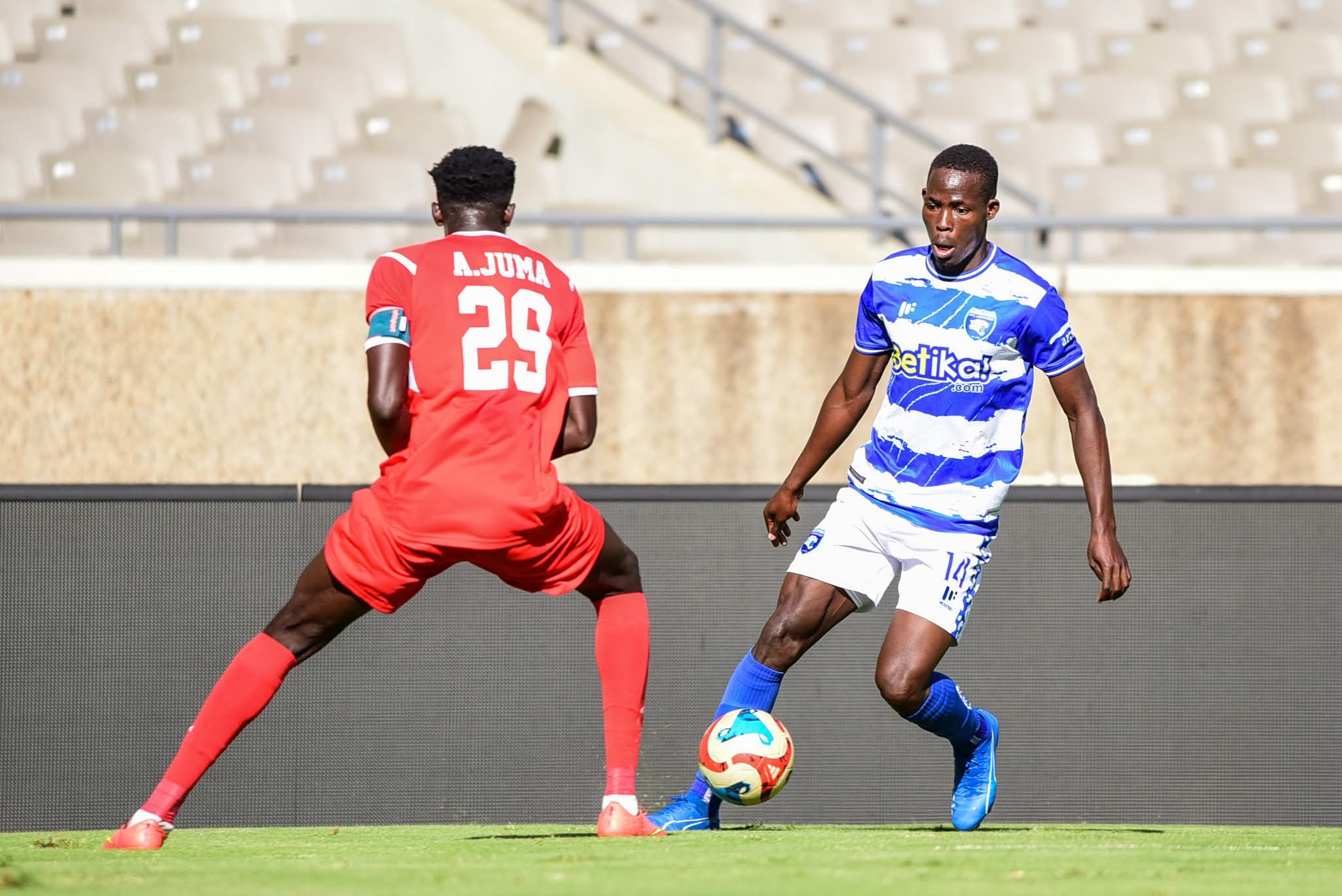 AFC Leopard's Samuel Ssenyonjo (14) tries to dribble past Bandari's Andrew Juma