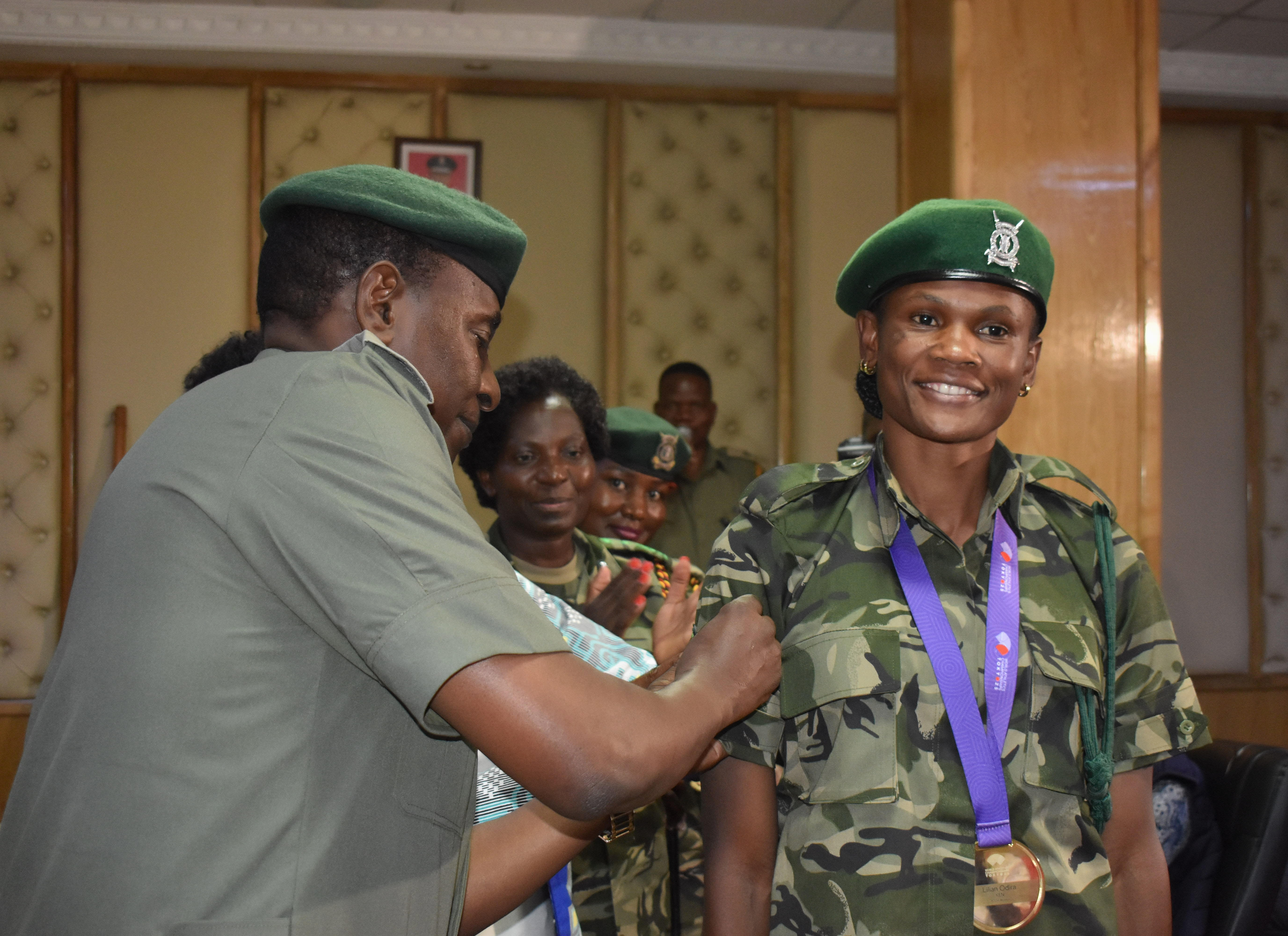 Kenya Prisons Commissioner General Patrick Arabduh promotes Lillian Odira as Assistant Commissioner General and Director of Sports, Catherine Ndereba, looks on