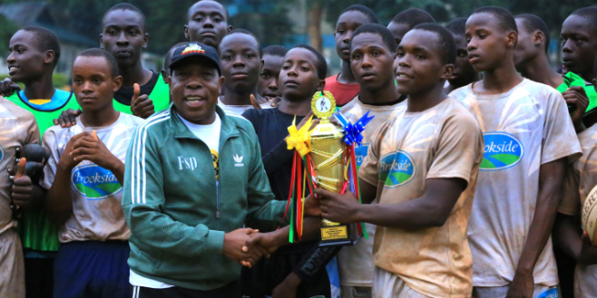 Kisii School captain Collins Mekenye receives the trophy from Friends School Poroko Chief Principal Titu Musyoki/ANGWENYI GICHANA