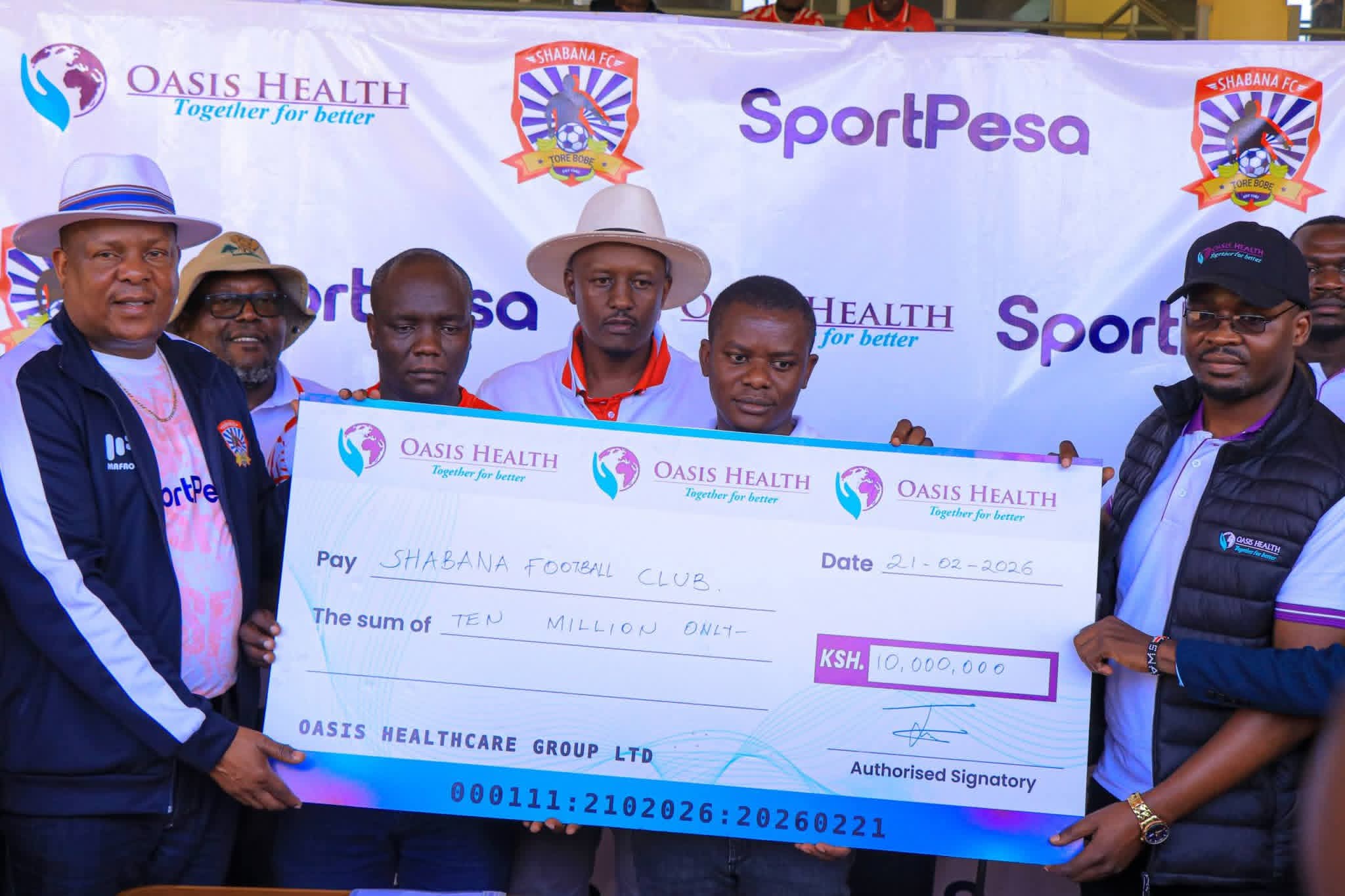 Shabana FC President Jared Nivaton (l) and Oasis Healthcare Group acting chief operations officer Joash Mwanzi (R) display a dummy cheque of Sh10 million