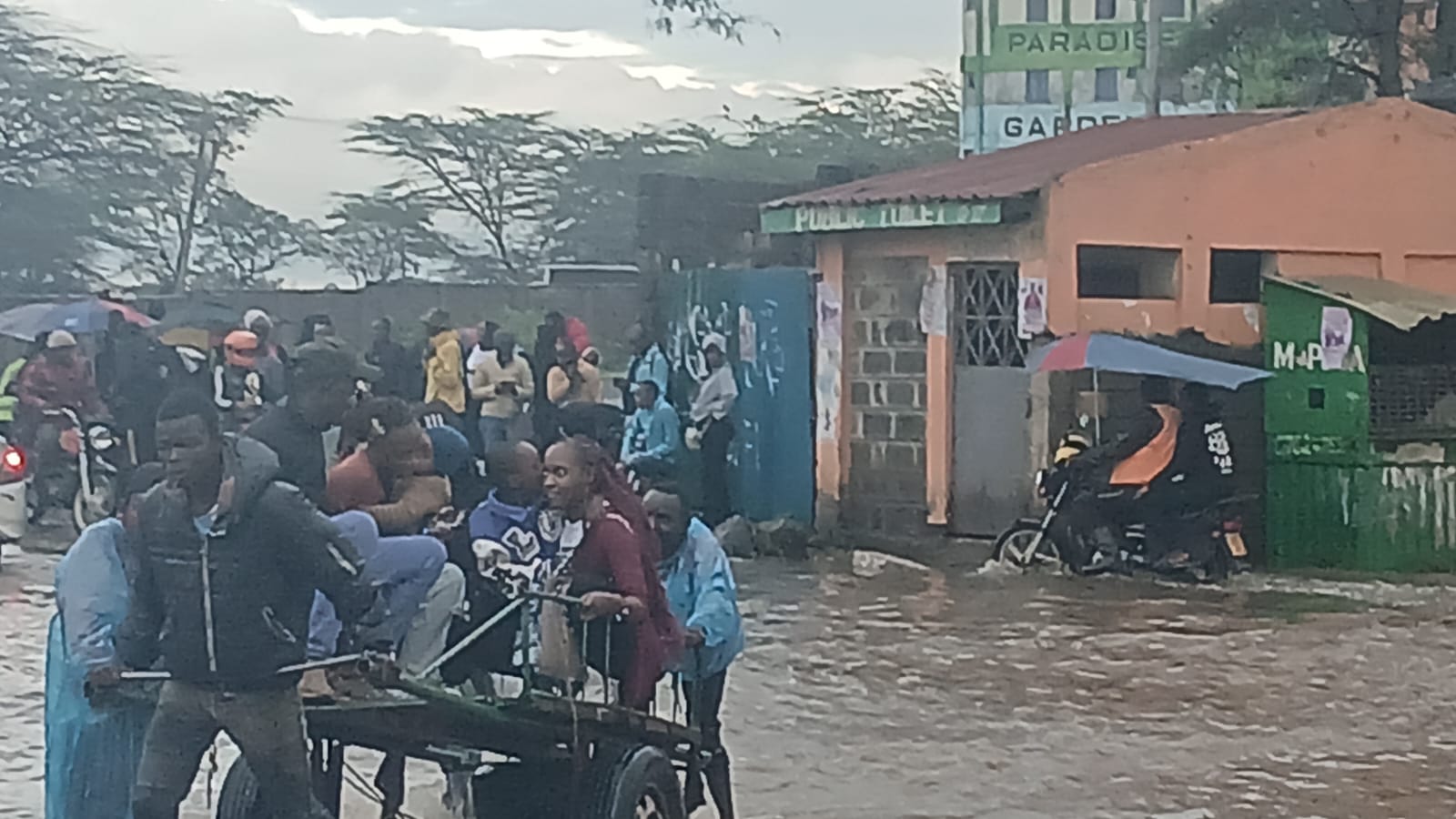 Youth charge Sh20 to help residents cross flooded roads in Nairobi