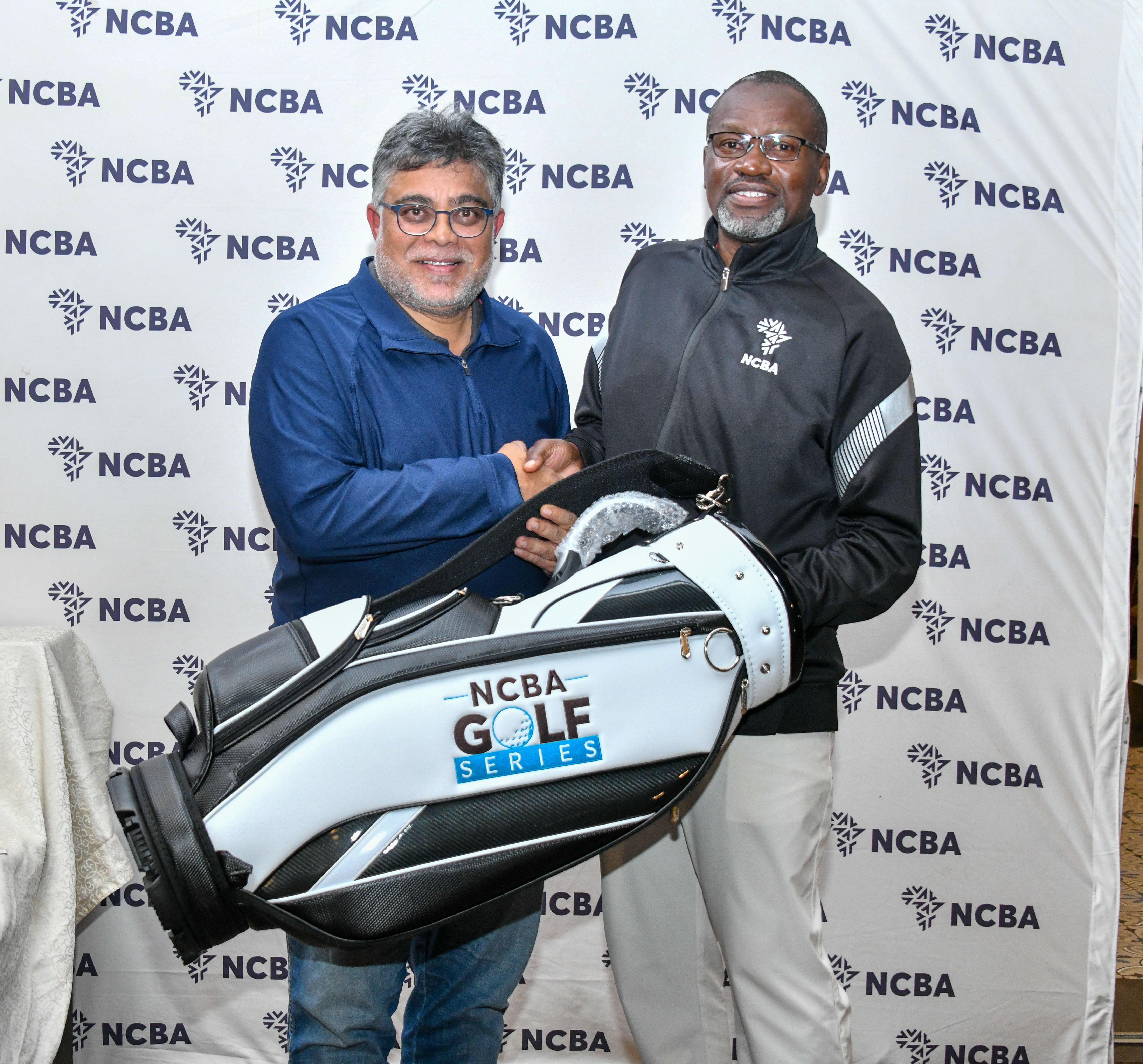 NCBA Golf Series Men's Gross winner Akshay Chandaria receives his prize  from NCBA Corporate Banking Director Charles Omondi
