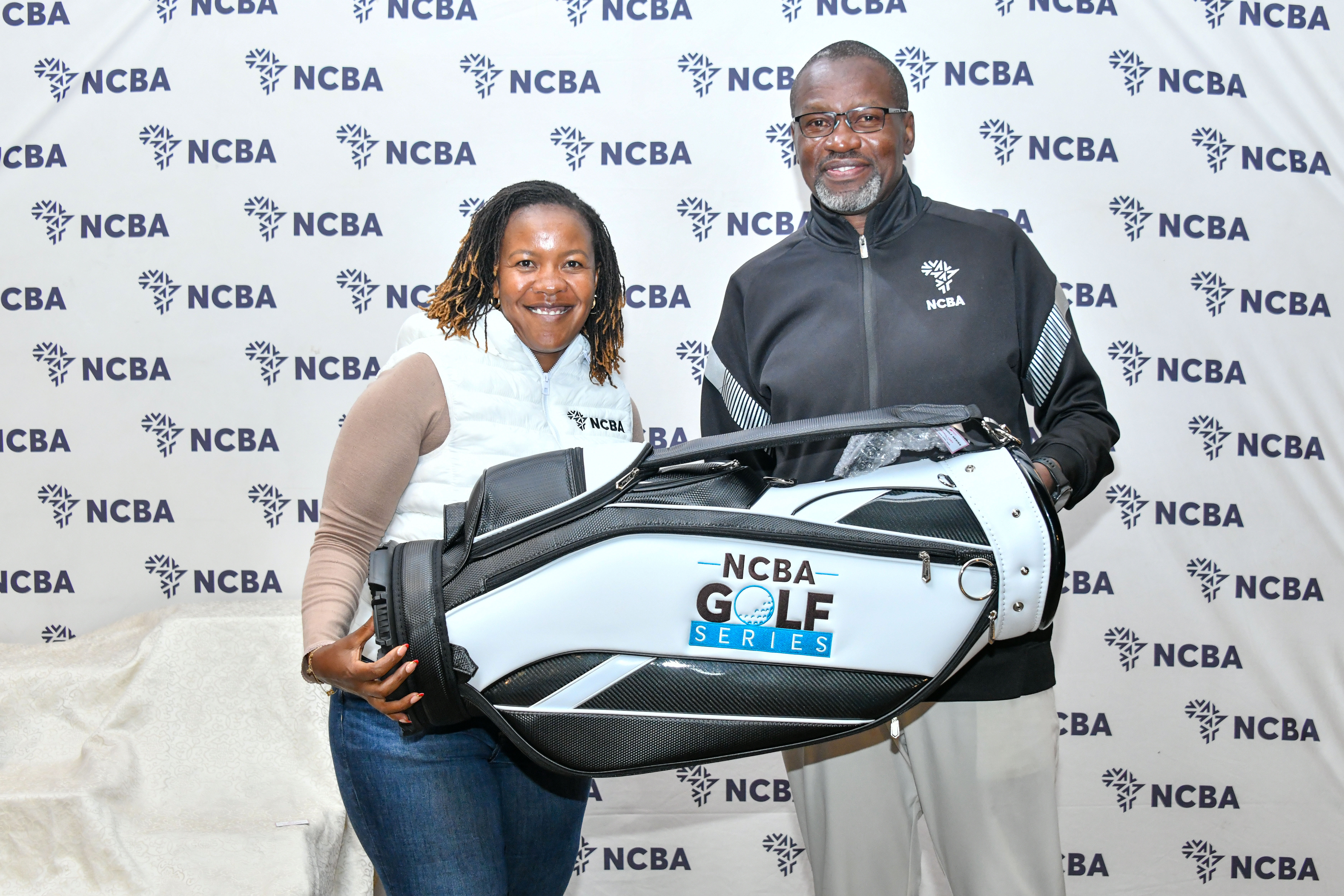 NCBA Golf Series Sigona Leg Ladies' Gross Winner Rachel Ndei receives her prize from NCBA Bank Corporate Banking Director Charles Omondi (L)