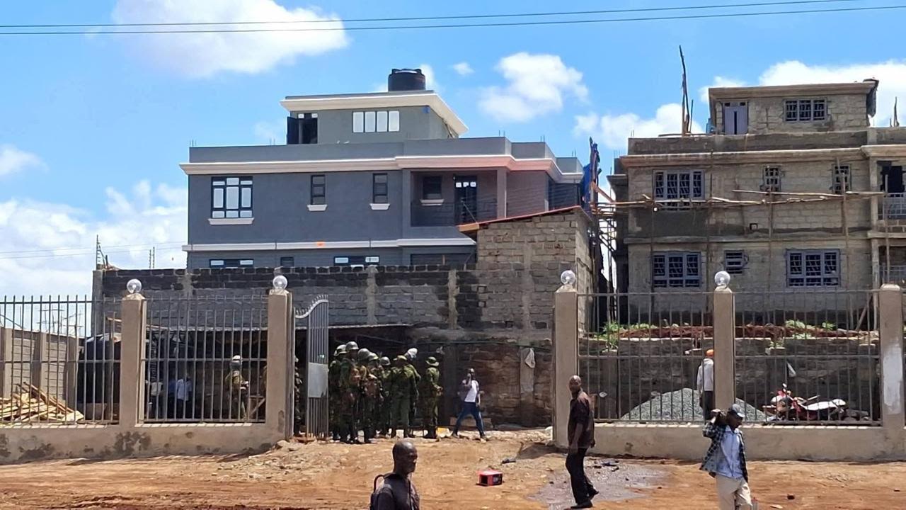 Police stand outside one of the targeted property in Marurui