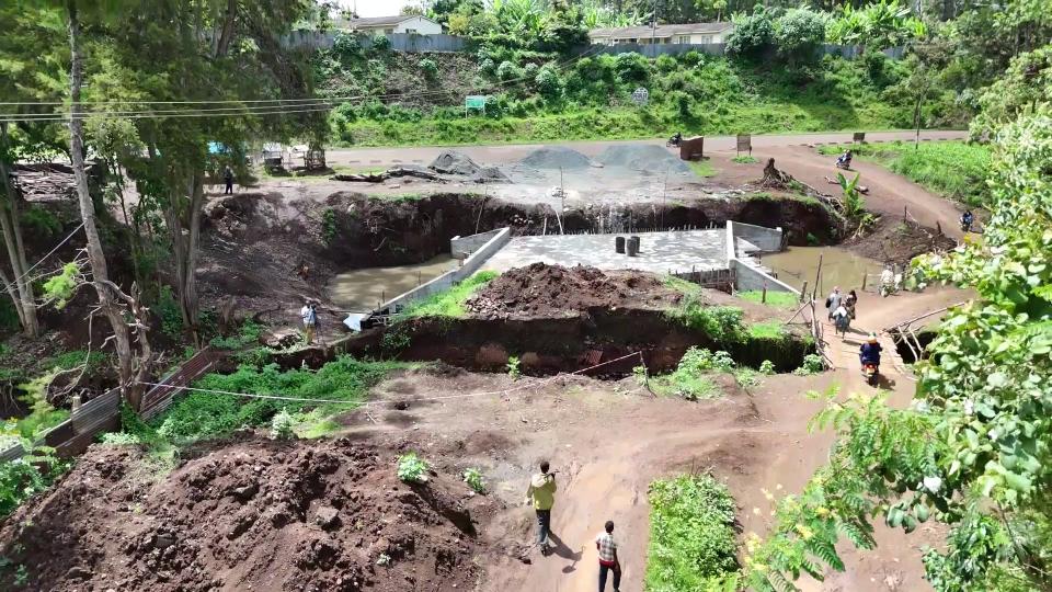 Residents crossing the make-shift Kiringa bridge right next to the permanent one being constructed by the government in Kabare ward, Kirinyaga/ ALICE WAITHERA