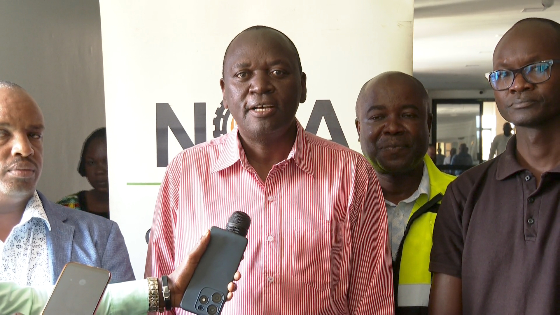 NCA General Manager in charge of Construction Research, Business Development and Capacity Building Dr. Chrispus Ndinyo (center) addressing the media in Kisumu on Thursday 7th May 2025.during a capacity building workshop for young contractors.