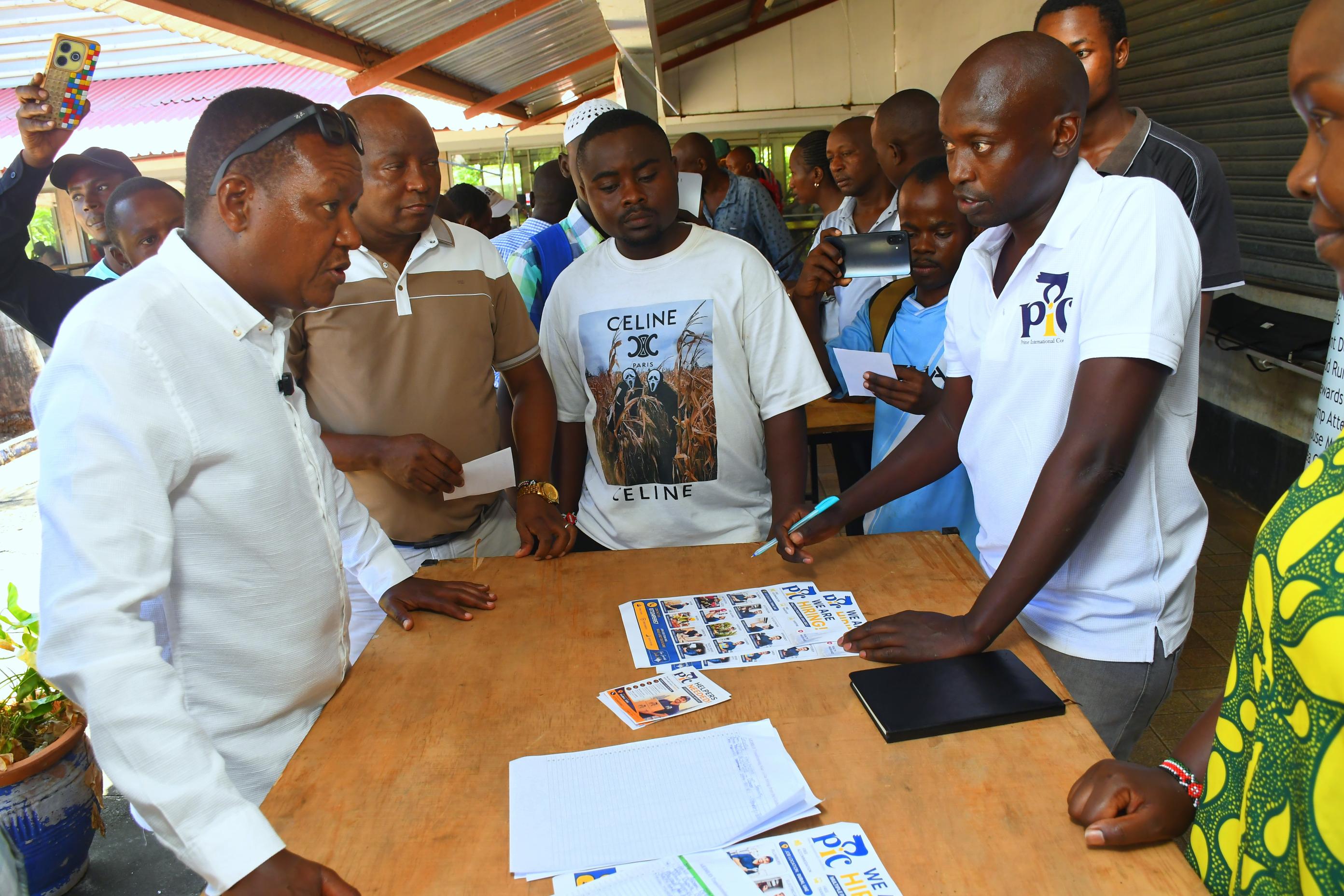 Cabinet Secretary (CS) for Labour Alfred Mutua (L) engages with a recruitment agent during the recruitment drive of the Kazi Majuu Program at the national Industrial Training Authority (NITA) Mombasa on 6, May 2026.