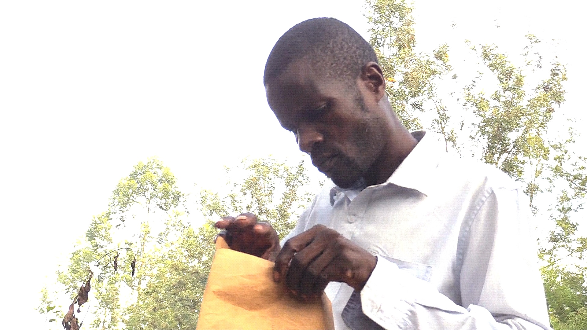 Ibrahim Hamisi checks medical documents for his son Patrick