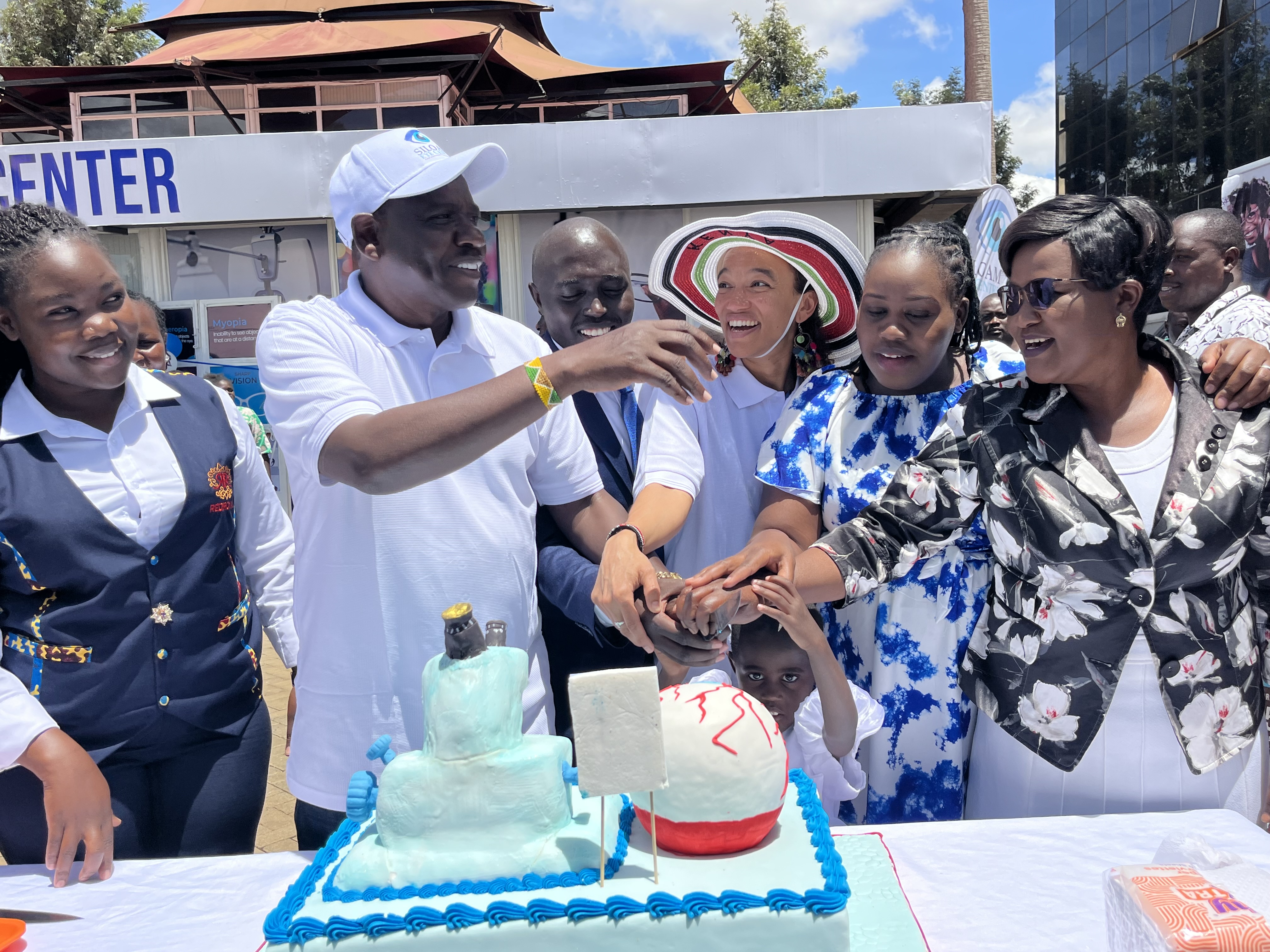 Governor Jonathan Bii leads cutting of a cake to launch Siloam Eye Center in Eldoret