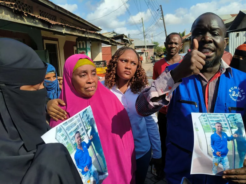Muhuri’s Francis Auma [R] and Fatima Jeilan [pink buibui], mother of Musa Awes, 23 [in poster] who was taken on April 19 in Barsheba, Mombasa by unknown people, never to be seen again, address the press on July 29 / BRIAN OTIENO
