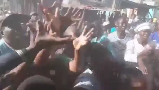Residents stretch to catch loaves of bread thrown at them by Nakuru Town West MP Samuel Arama. /SCREENGRAB