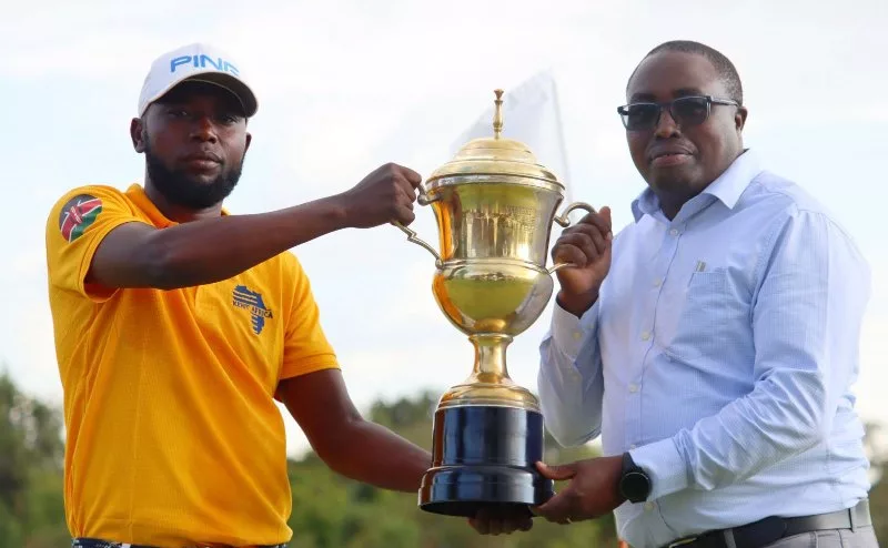NCBA Nanyuki Open winner Cyprian Bundi (l) receives his trophy from Nanyuki Sports Club captain Michael Mwirigi