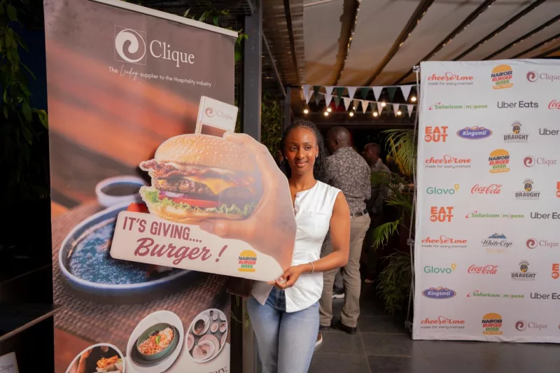 A lady holding a burger dummy at the Nairobi Burger week launch.