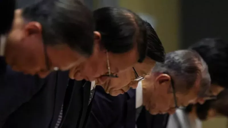 John Lee (centre) bowed in apology along with top officials/REUTERS via BBC
