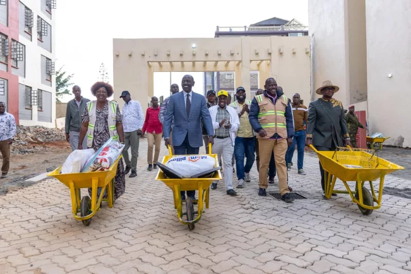 Ruto helps families move into homes with wheelbarrow